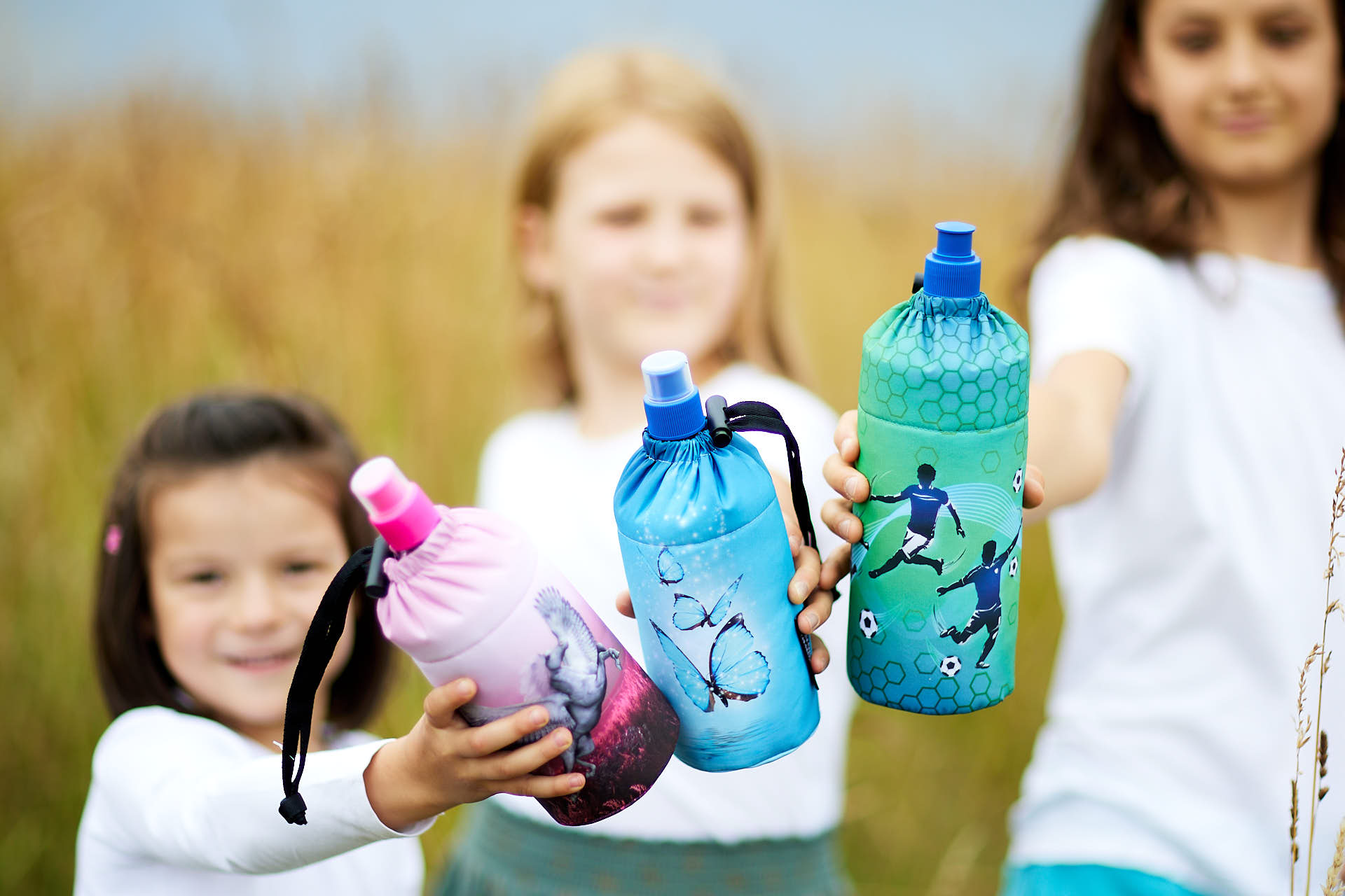 Kinder zeigen ihre Emil Trinkflasche in die Kamera