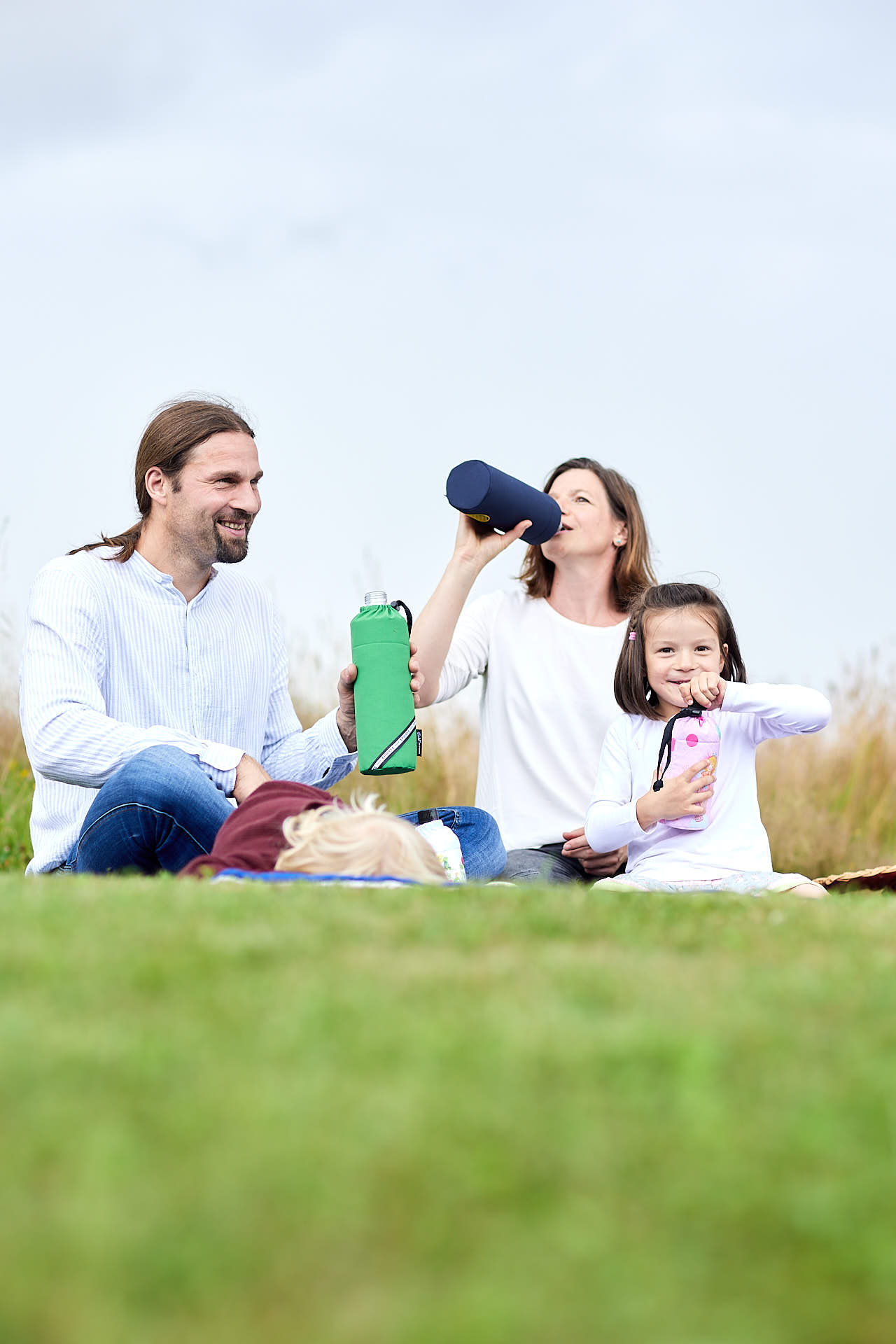 Familie beim Picknick mit Glas Trinkflaschen