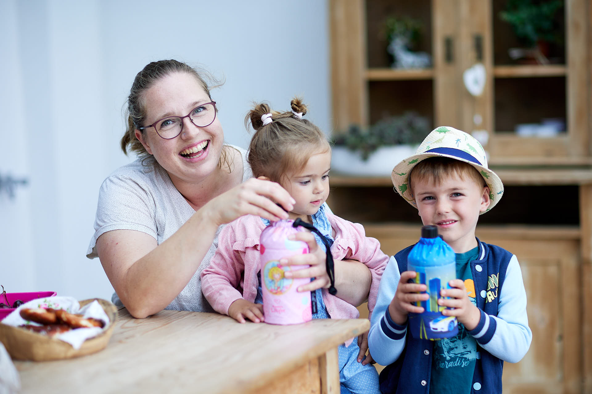 Mutter mit Kinder am Esstisch mit Emil Glas Trinkflaschen